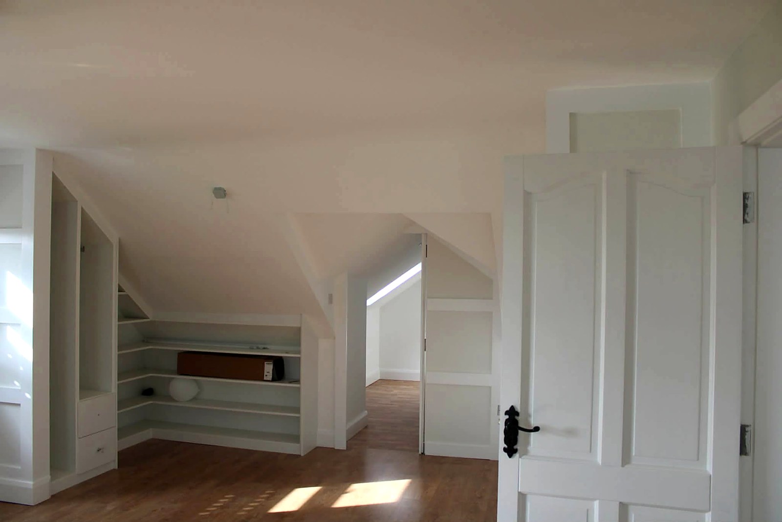 Attic room with built-in shelving, doors and skirting freshly painted