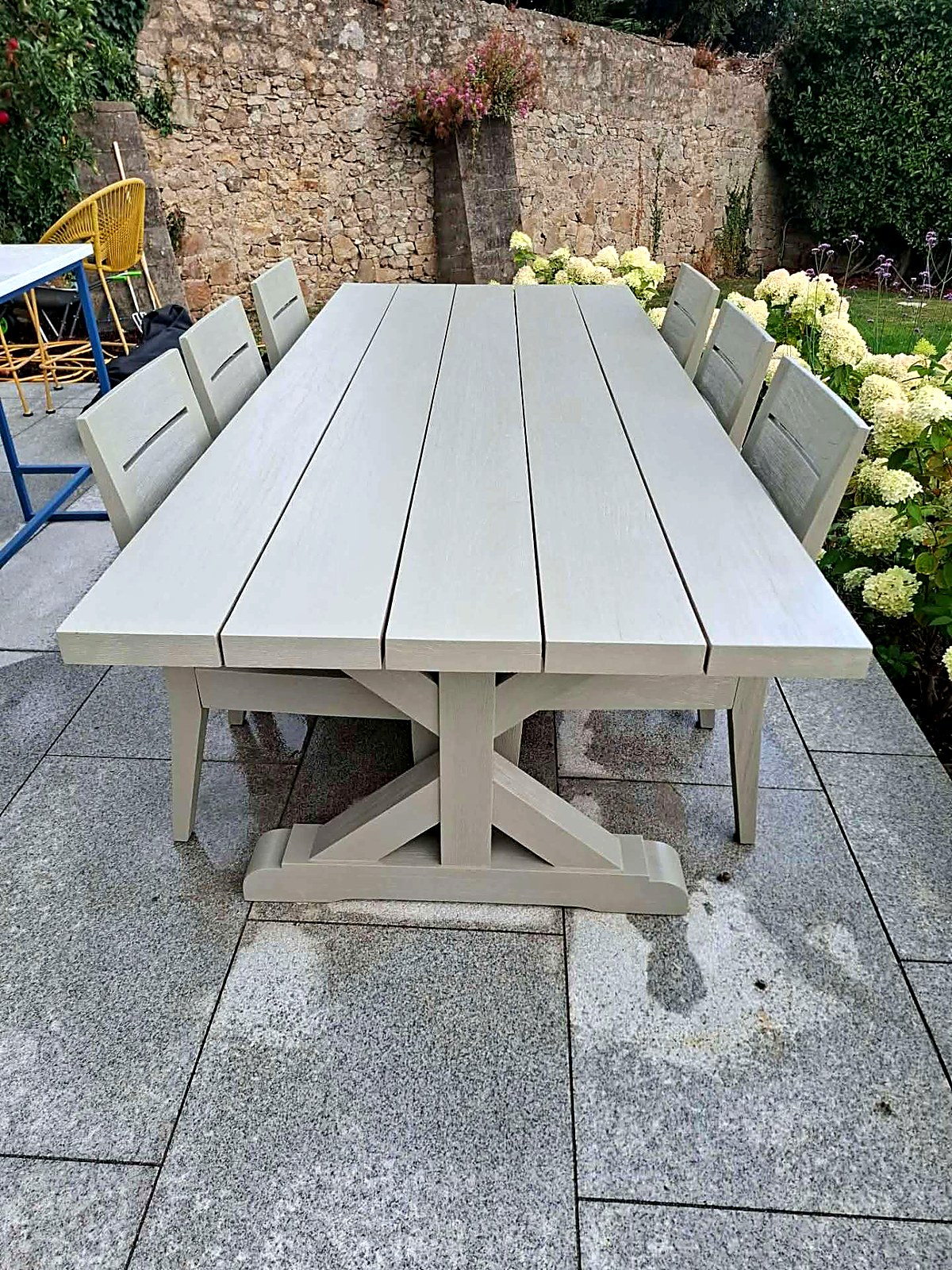 Outdoor teak dining table and chairs finished in a soft sage green