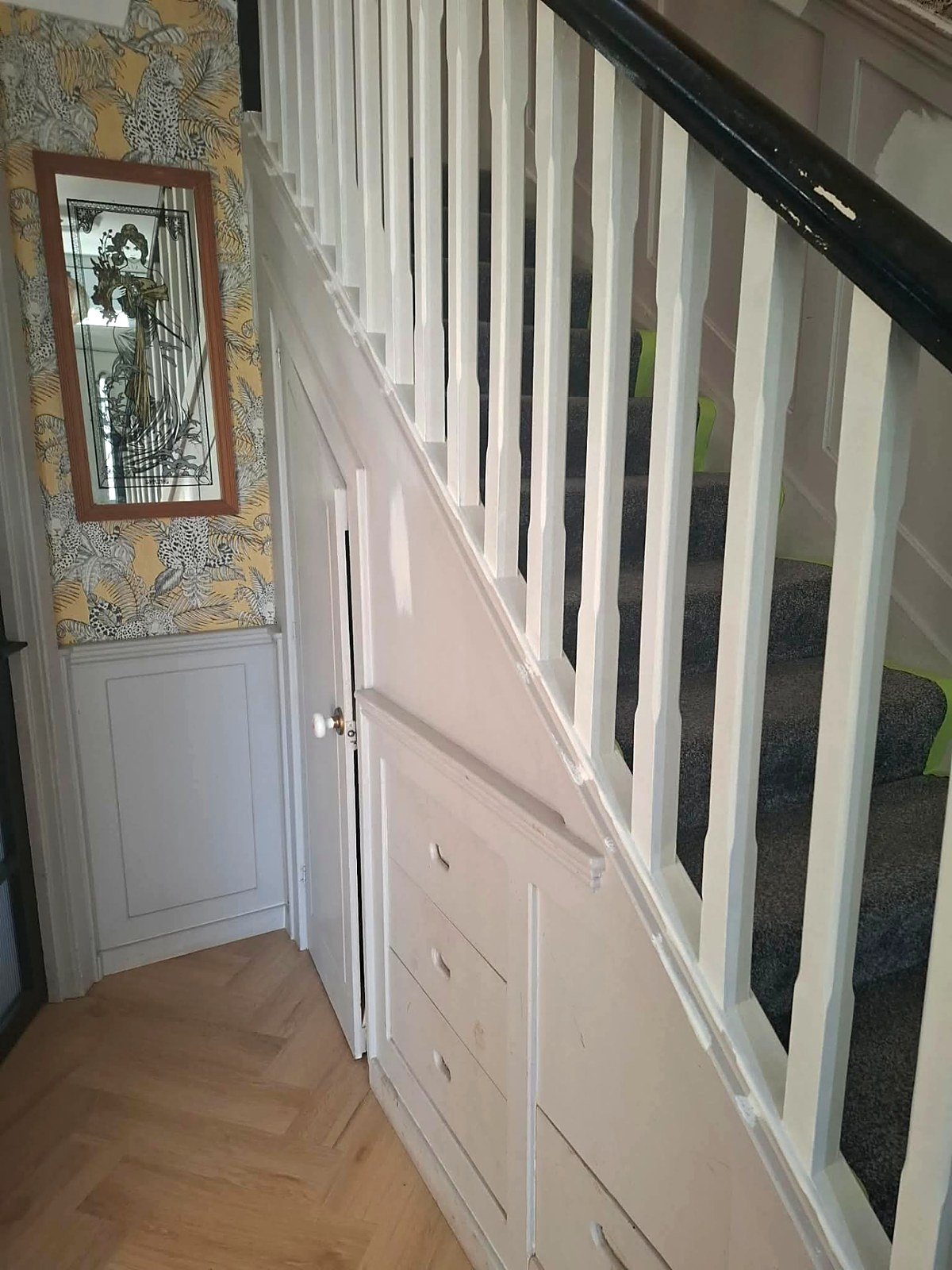 Under-stairs press and balustrade hand-painted in a soft chalk white