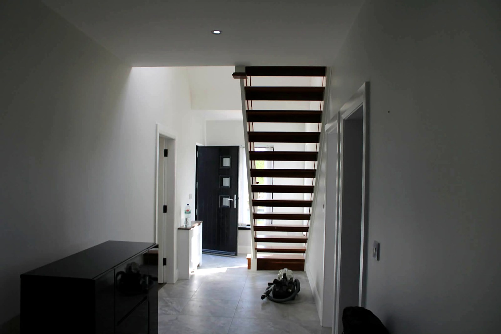 Entrance hall with open-tread stairs, painted walls and white joinery