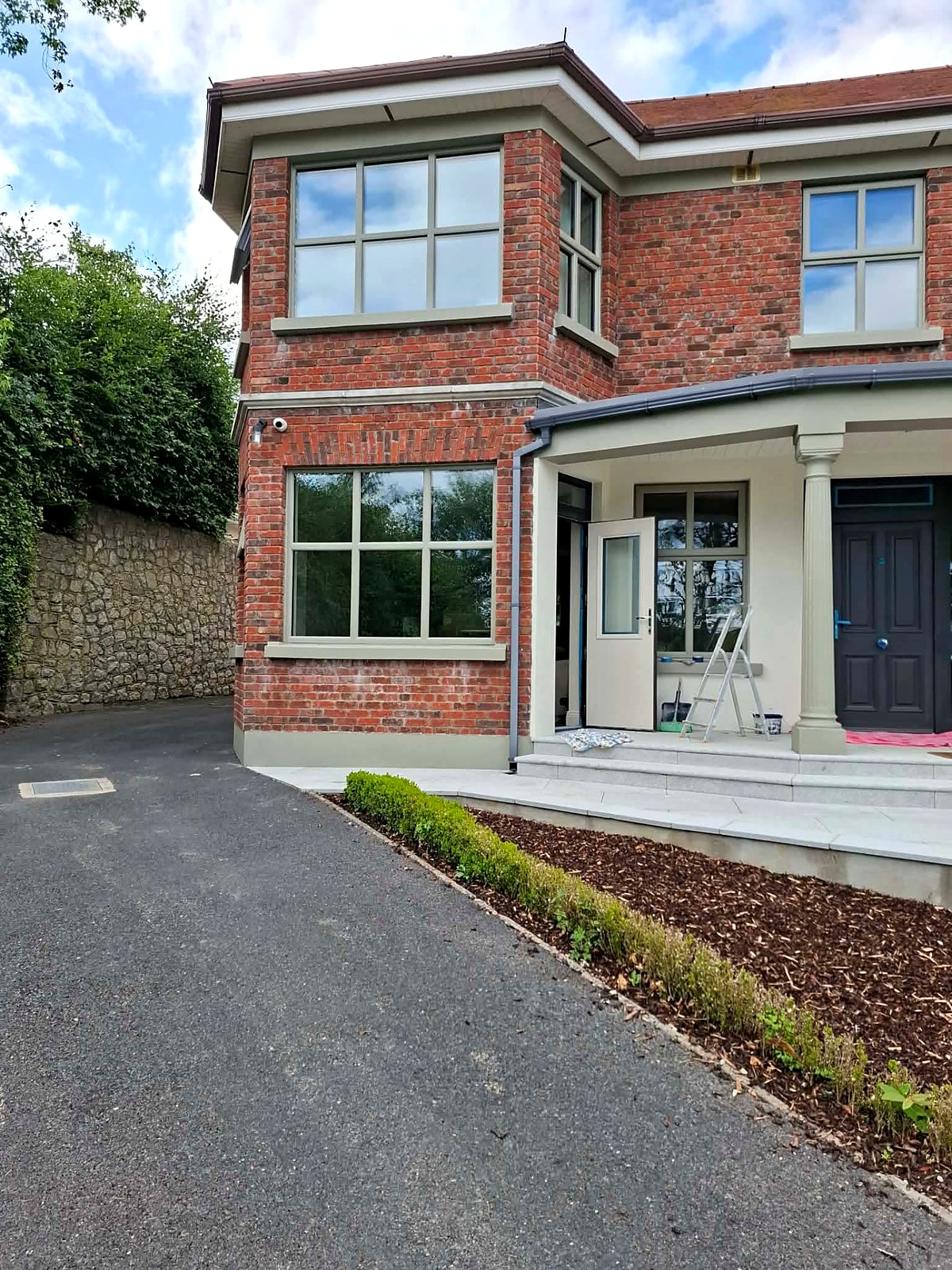 Bay windows with freshly painted frames, sills and plinth against red brick