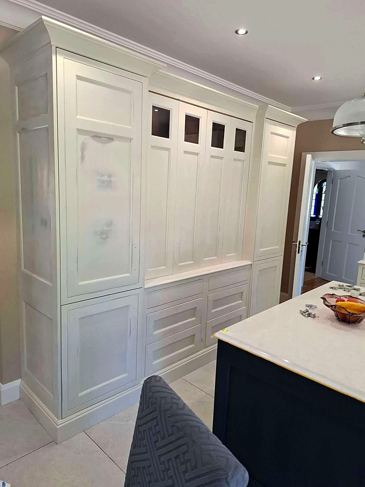 Freshly hand-painted cream larder and tall units in a family kitchen
