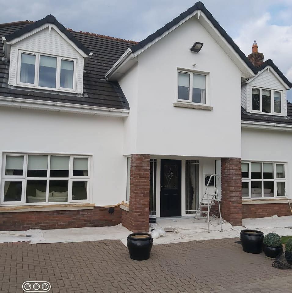 Two-storey house exterior freshly painted in clean white with brick detailing