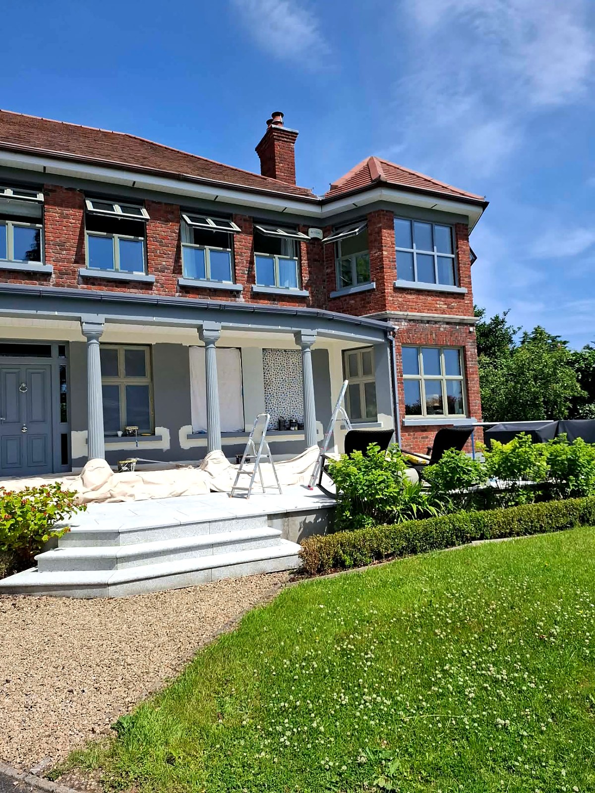 Full front elevation of a period red-brick house after a complete exterior repaint