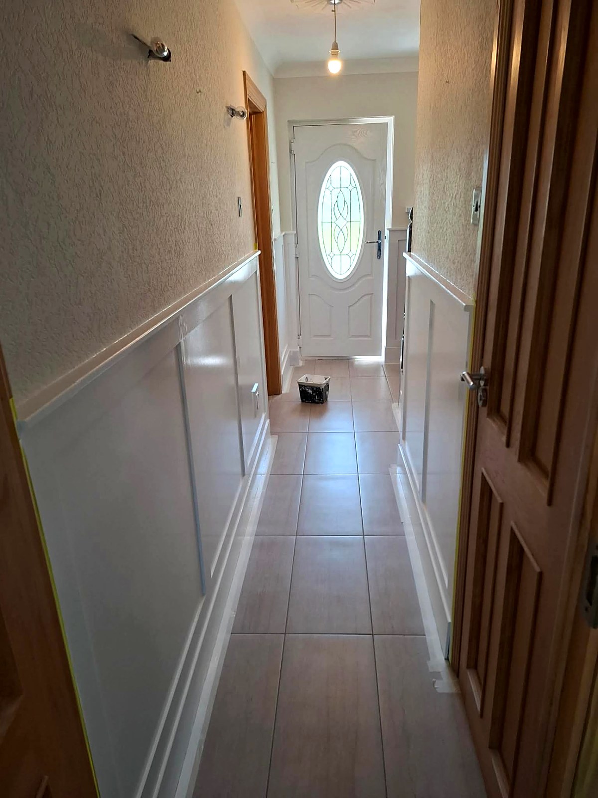 Hallway with newly painted white wall panelling and crisp skirting