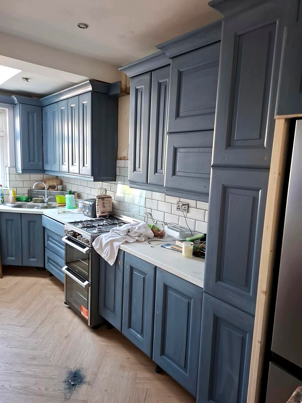 Close view of worn blue kitchen units and cornice before repainting