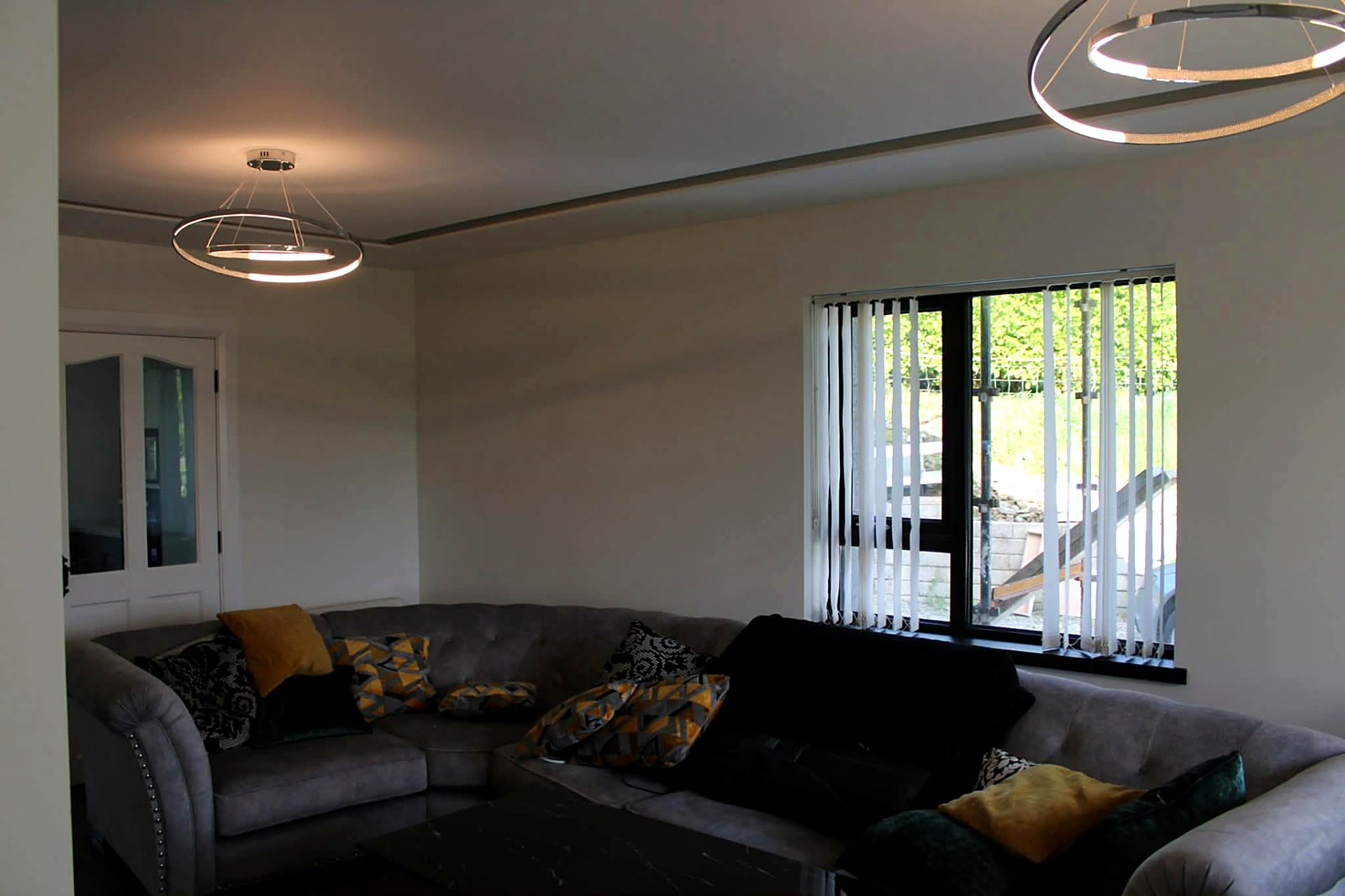 Living room painted in a soft warm white with feature ring lighting
